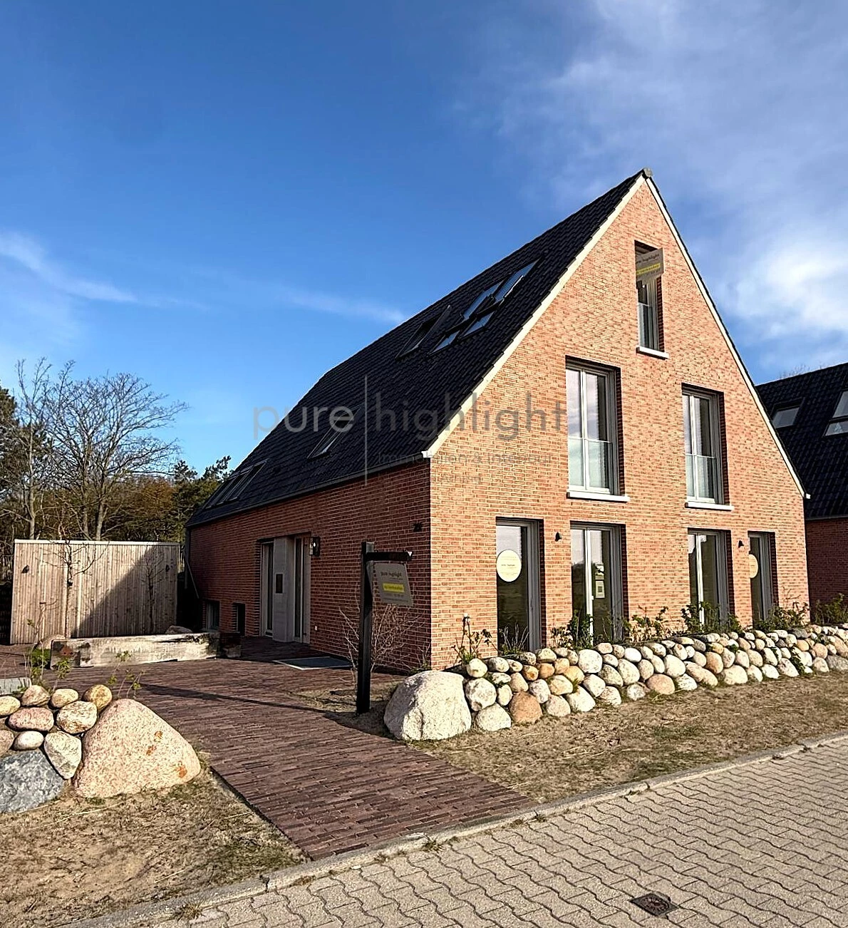 Verblendfassade, Satteldach und Findlingsmauer