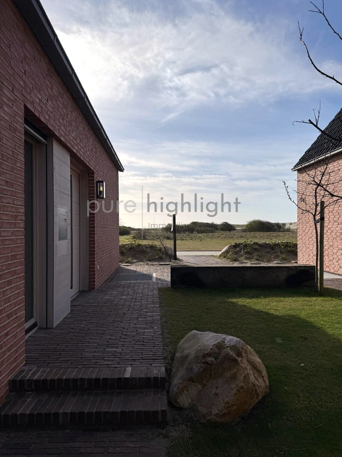 Gepflasterter Weg und freier Blick über die Dünenlandschaft
