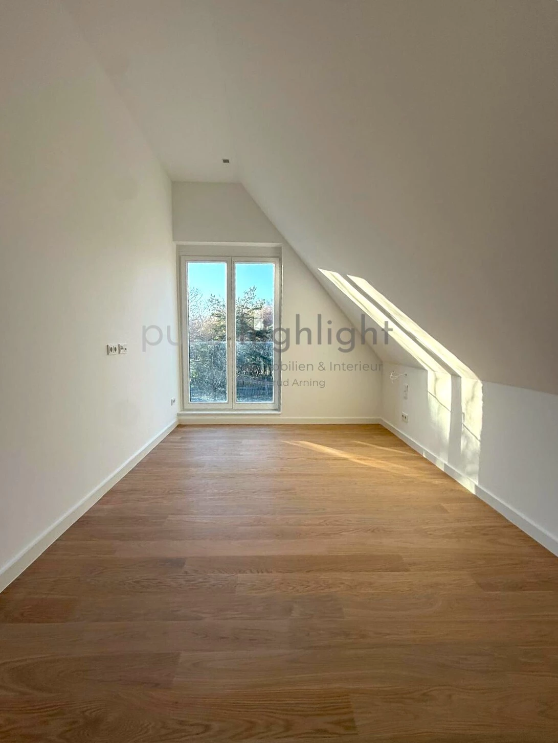Schlafzimmer unter der Dachschräge mit bodentiefem Fenster
