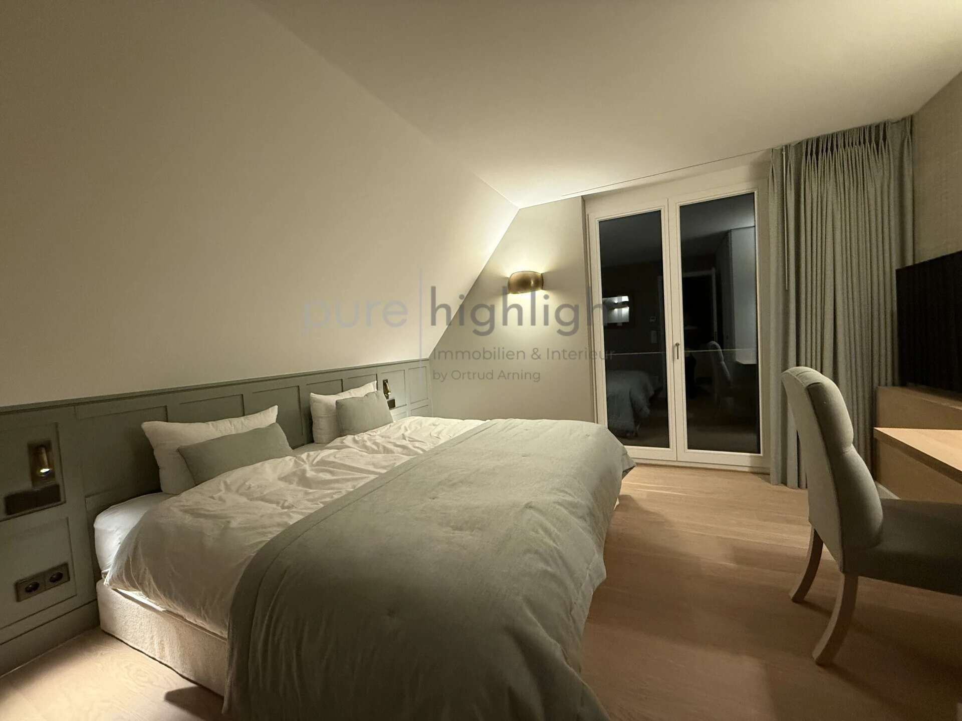 Schlafzimmer mit wandhoher Täfelung, indirekter Beleuchtung und Zugang zur Loggia