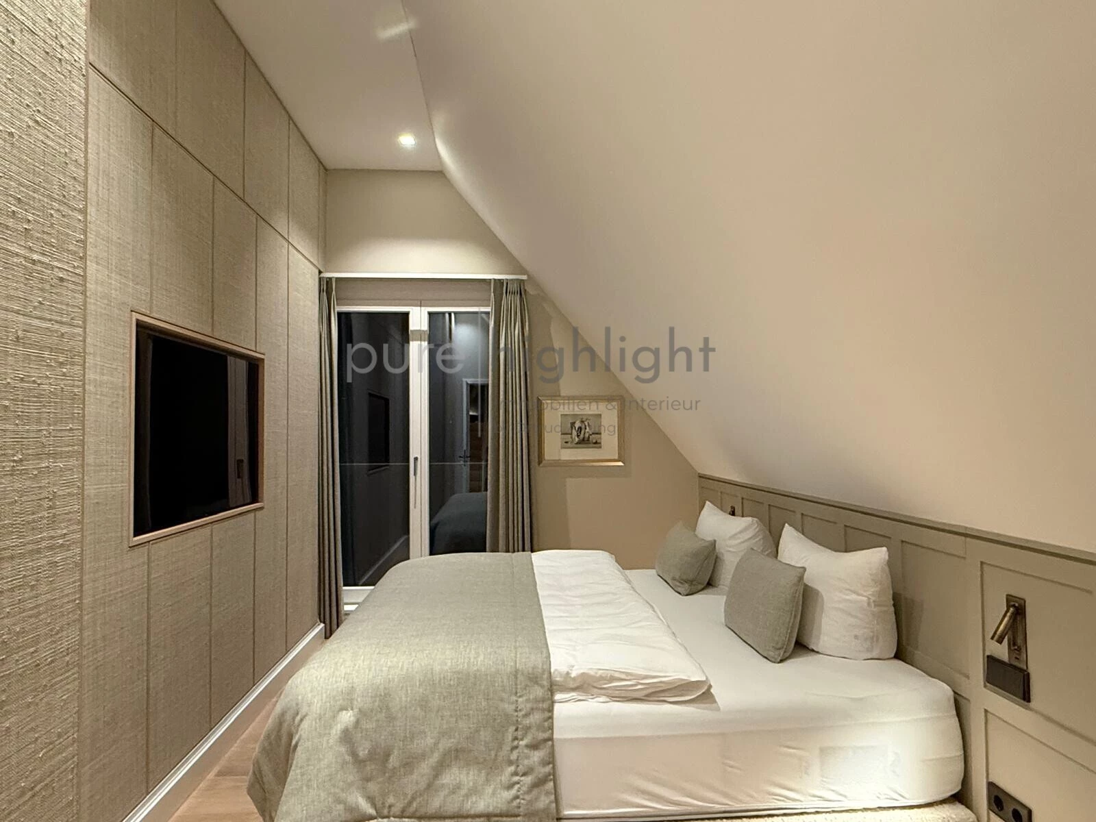 Schlafzimmer mit textiler Wandbespannung und Wandfernseher